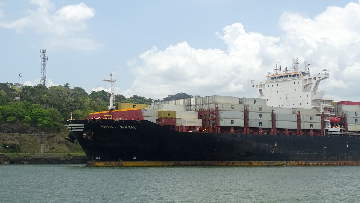 Buque de contenedores pasando opuesto en el canal de Panamá